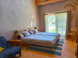 a bedroom with a large bed and a window at Mas la Llum, la casa de palla in Arens de Lledó