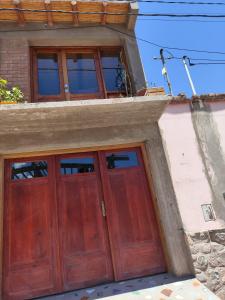 a pair of wooden doors on a building at susurros del viento in Tilcara
