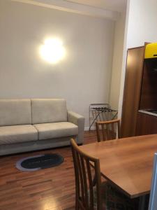 uma sala de estar com um sofá e uma mesa em ALMA Rooms Appia em Roma