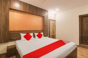 a bedroom with a large bed with red pillows at OYO Flagship Hotel R Square Grand in Hyderabad