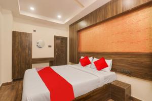 a bedroom with a large bed with red pillows at OYO Flagship Hotel R Square Grand in Hyderabad