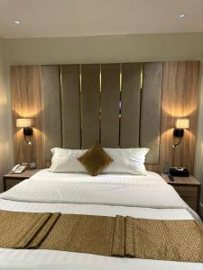 a bedroom with a large white bed with two lamps at Ghima Jeddah in Jeddah