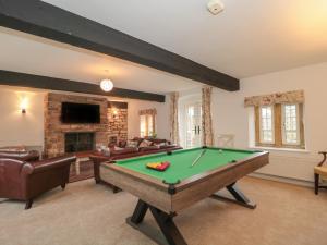 a living room with a pool table and a fireplace at The Stable House in Sherborne