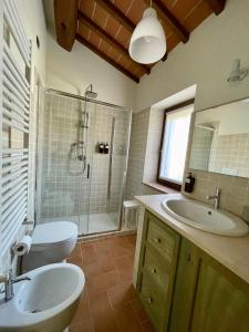 e bagno con lavandino, servizi igienici e doccia. di Casale dell'Assiolo - Affittacamere a Castiglione del Lago