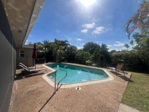 a swimming pool in the middle of a yard at 15Min from FLL airport W 8ft pool & NEW hot tub! in Sunrise