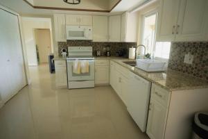 a kitchen with white cabinets and a stove top oven at 15Min from FLL airport W 8ft pool & NEW hot tub! in Sunrise
