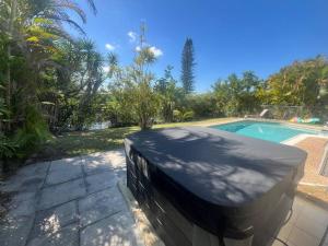 a swimming pool with a black cover next to a yard at 15Min from FLL airport W 8ft pool & NEW hot tub! in Sunrise