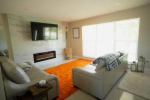 a living room with a couch and a fireplace at 15Min from FLL airport W 8ft pool & NEW hot tub! in Sunrise