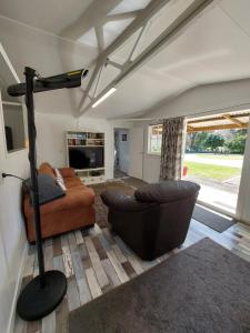 a living room with a couch and a lamp at 4 Palms Cottage Coromandel Town in Coromandel Town