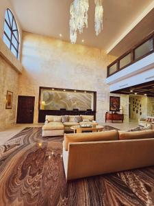 a large living room with couches and a chandelier at Hotel María Bonita Chihuahua in Chihuahua