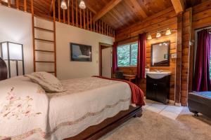 um quarto com uma cama e um lavatório em Alert Bay Lodge em Alert Bay