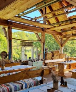 un gran pabellón de madera con bancos y mesas en Guest Accommodation Butina, en Kuterevo