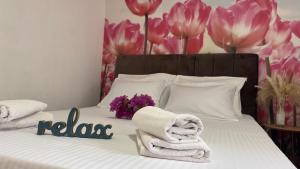 Una cama con toallas y flores con una pancarta en FAMILY apartment near Old Town, en Mostar