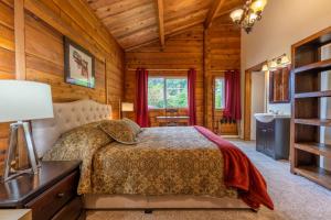 a bedroom with a bed in a log cabin at Alert Bay Lodge in Alert Bay