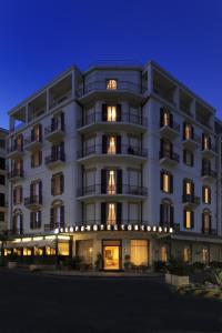 duży biały budynek z oświetleniem w obiekcie Hotel Europa & Concordia w Alassio