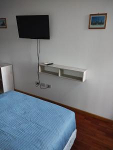 1 dormitorio con 1 cama y TV en la pared en Departamento calle 2 en La Plata
