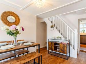 a dining room with a table and a mirror at Bells Cottage - Explore Cornwall by rail in St Austell