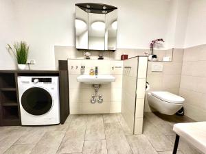a bathroom with a washing machine and a sink at Haus Sterntaucher Appartement 4 in Thiessow +21 photos