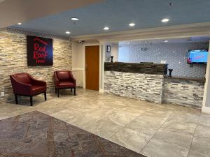 - une salle d'attente avec 2 chaises et une télévision dans l'établissement Red Roof Inn Auburn Hills, à Auburn Hills