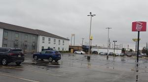 a parking lot with cars parked in the rain at Red Roof Inn Baton Rouge in Baton Rouge