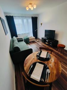 salon z kanapą i stołem w obiekcie Apartament Inka w mieście Goleniów