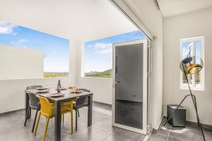 a dining room with a table and chairs and a window at Modern 3-Bed Apartment in Papaya Resort in Grote Berg