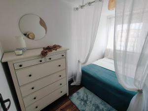a bedroom with a bed and a dresser with a mirror at Apartament Inka in Goleniów
