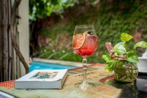 a glass of wine sitting on a table next to a book at Hotel Barahona Cartagena in Cartagena de Indias