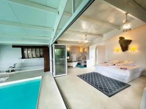Suite Loft de la Sirène Grande piscine privée في Marais-Vernier: غرفة نوم بسرير ومسبح