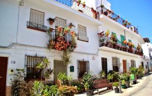 a white building with plants and a bench in front of it at La Viajera in Algarrobo +26 photos