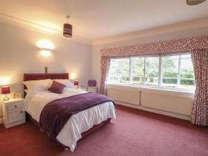 a bedroom with a bed and a large window at The Lodge in Grantham