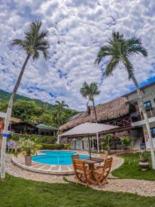 a resort with a swimming pool and palm trees at Hotel Randuky Tayrona in El Zaino