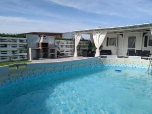 uma grande piscina com um grelhador num quintal em PALMAR A Tres Minutos Andando De La Playa NO GRUPOS em El Palmar
