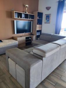 ein Wohnzimmer mit Sofas und einem Flachbild-TV in der Unterkunft Apartment Elvira in Opatija