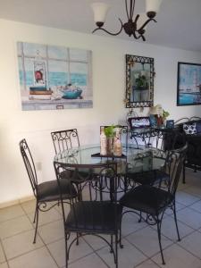 een eetkamer met een glazen tafel en stoelen bij Casita de descanso en la Ribera de Chapala in Chantepec