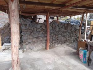 a building with a stone wall and a pole at Bring Your Camp in Hawaiian Ocean View