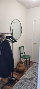 a room with a mirror and a green chair at Viihtyisä ja valoisa yksiö keskustan läheisyydessä in Heinola
