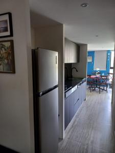 cocina con nevera y comedor en Grand Depa Bellomar, en Acapulco