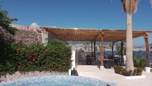 un complejo con piscina y pérgola de madera en Grand Depa Bellomar, en Acapulco