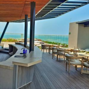 - un restaurant avec des tables et des chaises sur la plage dans l'établissement Moderno Apartamento Salida directa al Mar Club de playa, à Santa Marta