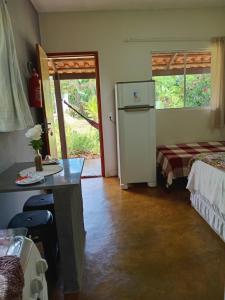 um quarto com um frigorífico, uma cama e uma janela em Recanto São Francisco de Assis em Pirenópolis