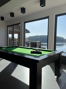 una mesa de billar en una habitación con vistas al agua en Rybacka Osada, en Piecki