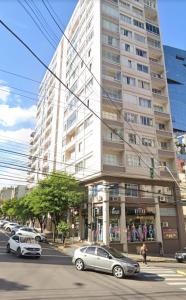 a large building with cars parked in front of it at Apto central completo 3 dormitórios in Caxias do Sul