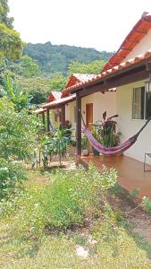 a house with a hammock in front of it at Recanto São Francisco de Assis in Pirenópolis