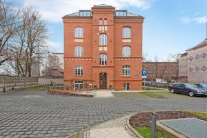 a brick building with a car parked in front of it at Waterlane Vintage - Fitness & Gym by Blue Mandarin in Gdańsk