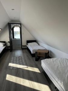 a attic room with two beds and a window at Rybacka Osada in Piecki