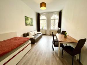 1 dormitorio con cama, mesa y sofá en Am Kiez von Leipzig en Leipzig