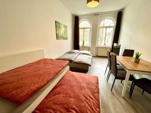 1 dormitorio con 2 camas, mesa y comedor en Am Kiez von Leipzig en Leipzig