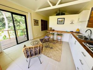 a kitchen with white cabinets and a table and chairs at Latui Loft in Savusavu