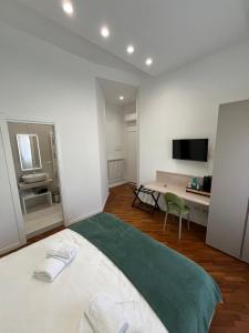 ein Schlafzimmer mit Bett, Schreibtisch und Fernseher in der Unterkunft Maison Grimaldi in Neapel